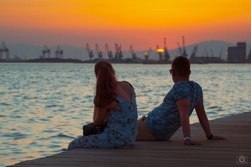 Romantic Couple Sitting on the Pier at Sunset - High-quality free Photo in cattegory Sunset / Backgrounds from FreeArtBackgrounds.com